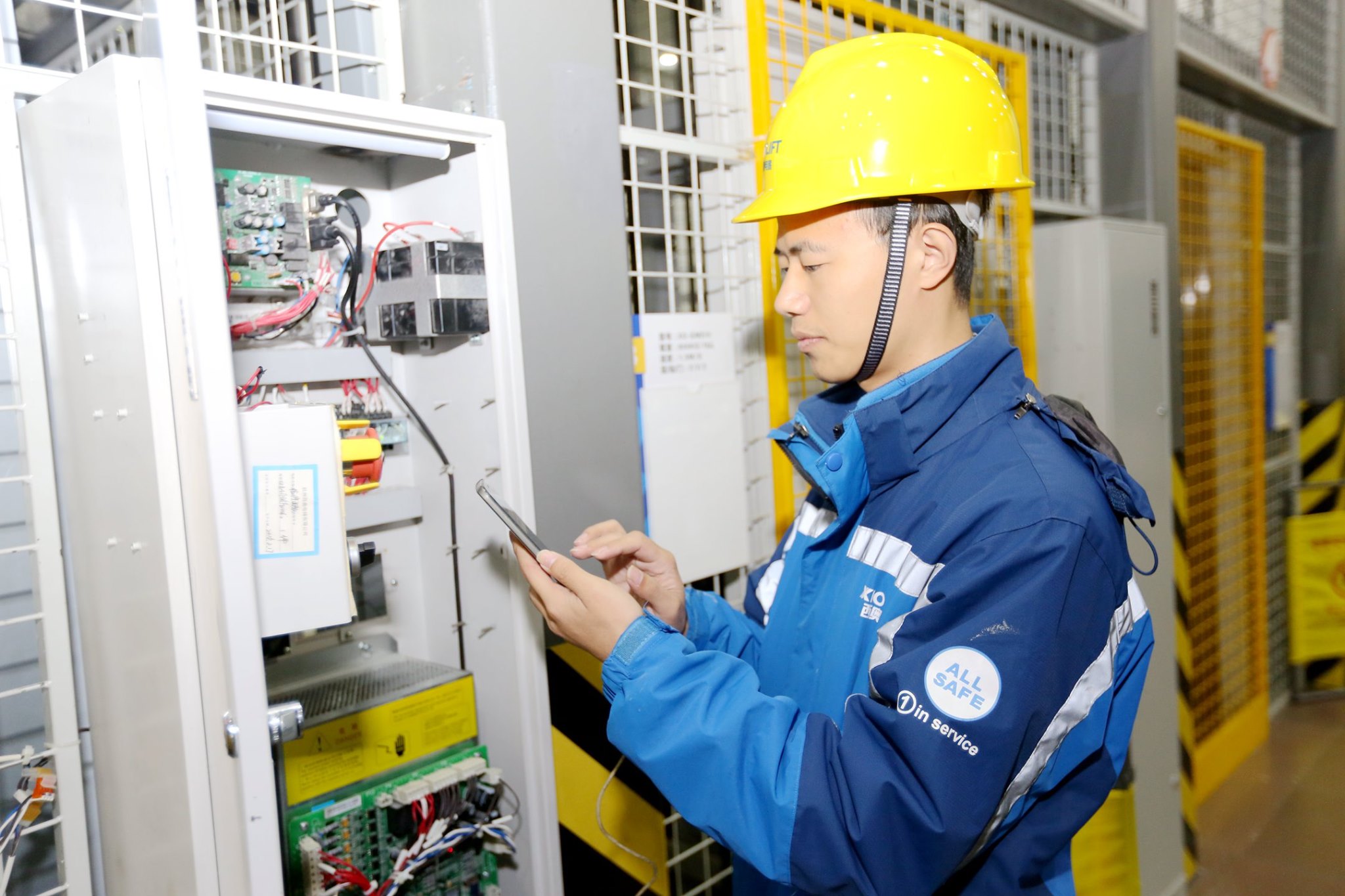 XIOLIFT technician inspecting an electrical control cabinet