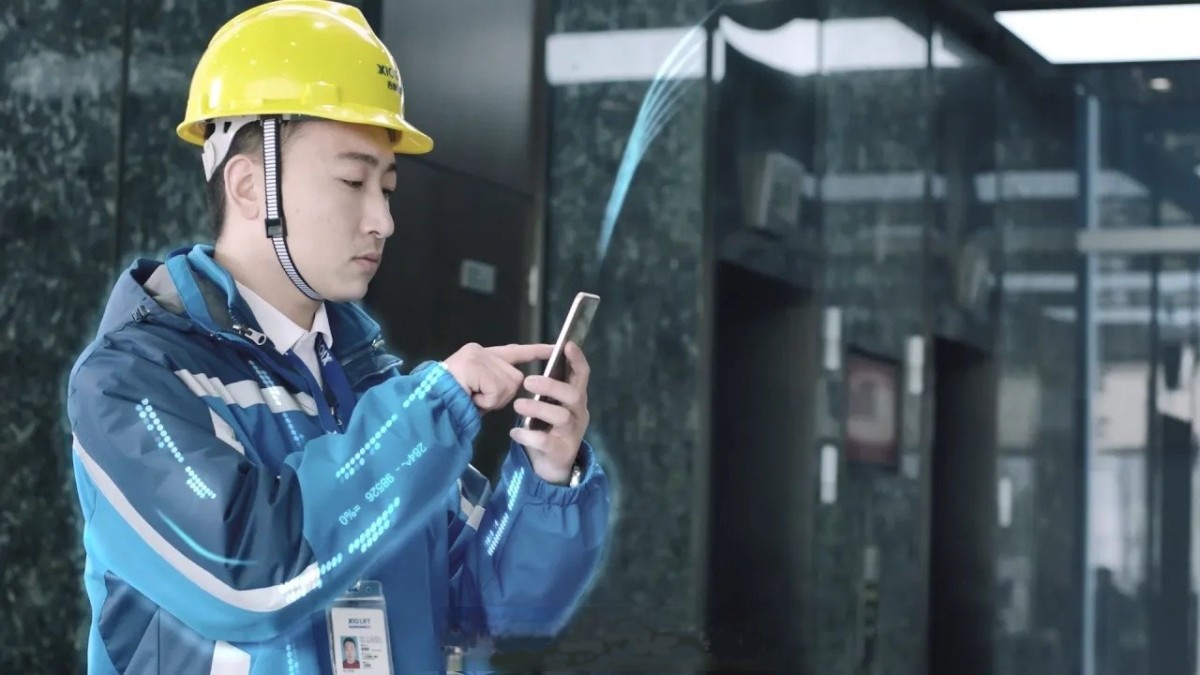 XIOLIFT technician inspecting a lift with a tablet